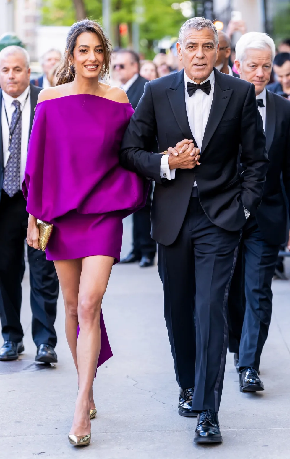 George and Amal Clooney hold hands at the gala