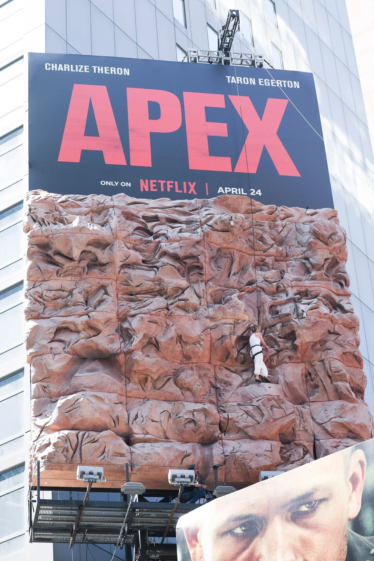 The actress scaled the structure while being attached to a harness