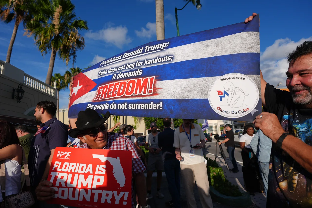 People hold signs as a group of Cubans turns out to show support hours after federal prosecutors announced charges against former Cuban President Raul Castro in the 1996 downing of civilian planes operated by Miami-based exiles, Wednesday, May 20, 2026, in Miami
