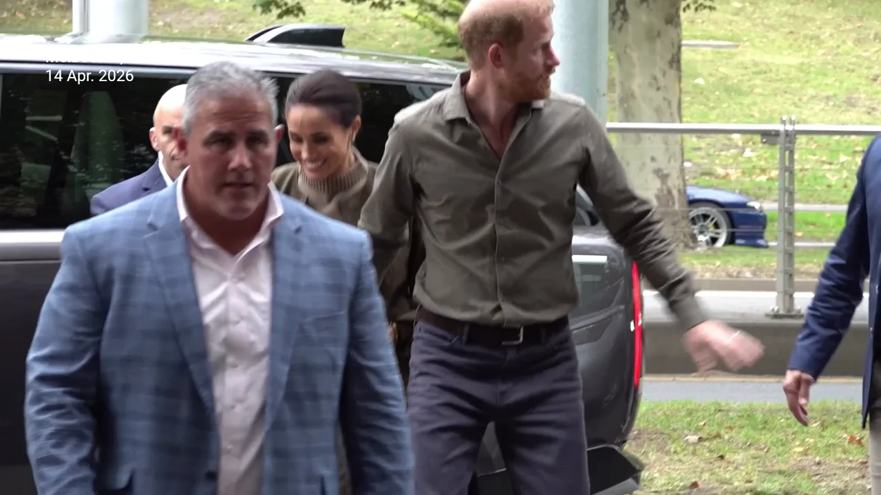 Prince Harry shows his protective side as Meghan Markle tightly holds his arm in Australia