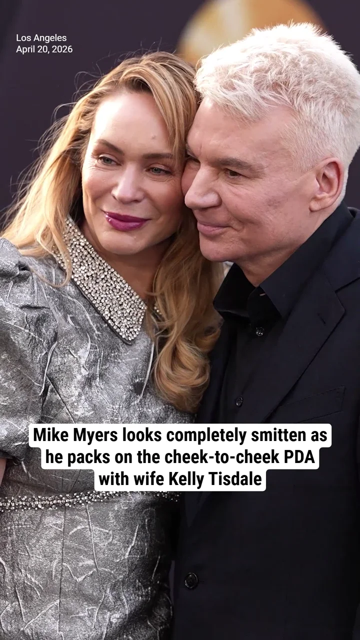 Mike Myers looks completely smitten as he packs on the cheek-to-cheek PDA with wife Kelly Tisdale